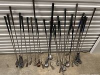 Full view of all golf clubs standing, showing the variety and number of clubs with steel shafts and different head styles.
