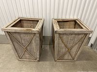 Two large wooden planters showing weathered wood finish and rope crossed on sides.