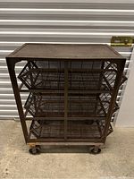 Front and side view of the vintage metal cart showing the three wire mesh baskets and four wheels.