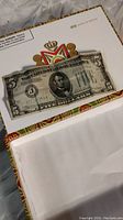 Full view of vintage 1934 $5 bill laid flat on decorative surface with envelope partially visible.