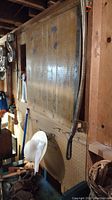 Large vintage paper cutter mounted on wall with wooden board and measurement grid on surface