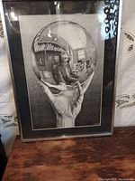 Framed MC Escher lithograph print showing reflective sphere and studio room.