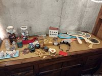 Wide view of mixed lot of decorative and collectible items on cabinet.
