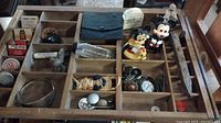 Full view of tray and contents showing multiple compartments with various vintage items including figurines, bottles, buttons and rusty tool.