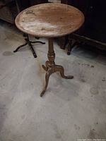 Full side view of the vintage solid wood plant stand or side table showing round top, turned column, and tripod base