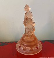 Full view of pink frosted glass Art Deco lady figurine on matching round flower frog base with carved patterns and holes