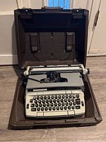 Eaton Viking typewriter inside brown hard carrying case showing keyboard and body