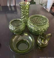 Top view of all five green glassware pieces showing textures and shapes.