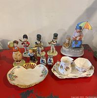 View of various figurines including toy soldiers, boy figurine, and Taylor & Kent China sugar and creamer set with plate.