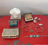 Lot overview showing silver jewelry rings, bangles, turquoise stone pendant marked 925, beaded cosmetic bag, milk glass hobnail bowl, vintage Lanvin lighter box, floral and silver brooches, and cufflinks.