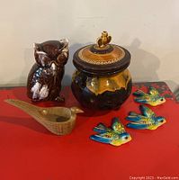 Photo showing the full lot including the brown and white chalk ware owl figurine, the Royal Canadian art pottery jar with squirrel knob lid, the hand-carved wooden pheasant, and three small brightly glazed ceramic bird plaques.