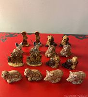 Overview of all figurines on red surface showing multiple pairs of Wade Whimsies animal and decorative figurines.