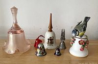 Overview of all seven bells together displaying variety in size, material, and design.