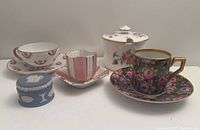 Photo showing three demitasse cups and saucers, Minton covered jelly jar, and blue Wedgwood Jasperware pill box