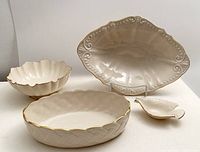 Four Lenox ceramic bowls arranged with Chadwick Centerpiece serving bowl, Dove dish, Symphony candy dish and Lattice Collection oval bowl visible; cream color with 24k gold trim on some pieces