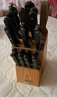 Knife block filled with black-handled Farberware knives arranged vertically