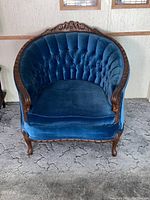 Front view of upholstered French Provincial side chair showing barrel back, tufted backrest, carved wood crest and cabriole legs