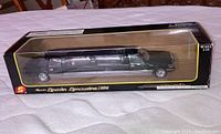 Side view of Lincoln limousine model in original black and yellow box with clear plastic window showing the detailed 12.5-inch die cast model.