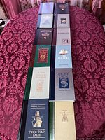 Top down view of all 12 books laid out on table, showing covers with titles and author names.