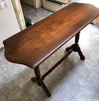 Wooden side table showing top surface and legs, with visible scratches and worn areas.