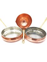 Top view showing two 10 inch copper frying pans with different interior finishes and a copper zabaglione bowl in center, all with brass handles.