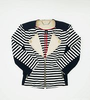Full flat lay image of Black and White striped womens jacket with cream lapels and gold zipper laid out on a white background.