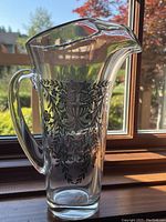 Glass water pitcher front view showing floral silver overlay design and applied handle.