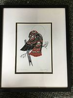 Full view of framed indigenous art print depicting a red tailored hawk perched on a branch, showing the matting and wood frame.