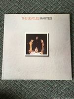 Front cover of The Beatles "Rarities" LP album showing white textured cover with centered photo of band members.