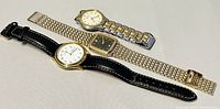 Three men's vintage quartz watches displayed on a surface showing overall look including metal and leather bands.