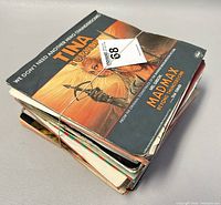 Stack of 45 RPM records tied with rubber band, including Tina Turner and Mad Max single on top