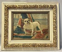 Framed vintage print of a bulldog standing on a British flag, set by the seaside, in a gold and white decorative carved wooden frame.
