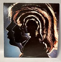 Front album cover with silhouette profiles of band members.