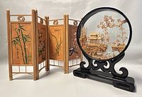 Image showing round handcrafted cork art on black stand next to 4-panel wooden mantle display with Chinese paintings.