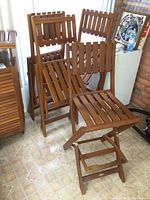 Four folding teak chairs arranged together
