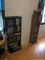 Black wood veneer DVD shelf loaded with DVDs