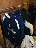 Four Maple Leafs garments hanging on a rack: pullover hoodie, crewneck sweatshirt, ski jacket and wool jacket