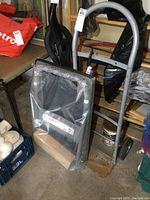 Steel hand cart with solid wheels and plastic platform hand truck in plastic wrap in storage area.