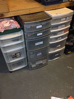 Overview of three plastic organizers with various contents under shelf.