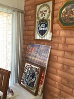 Two Old Vienna mirrored clocks and one framed Old Vienna poster leaning against wall showing sizing and condition.