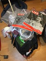 Photo showing basket filled with vintage magazines, slippers, plush toys, and miscellaneous items.