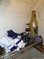 Toronto Maple Leafs apparel and memorabilia including jerseys, ball cap, bottle banks, books, towels, and large jacket patch on a closet shelf