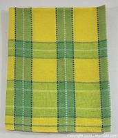 Folded view of yellow and green plaid tablecloth showing pattern details