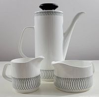 Front view of coffee pot, creamer, and milk pitcher showing geometric black Scraffito pattern on white ceramic