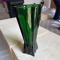 Single green rocket style glass vase with vertical faceted design and glossy finish.