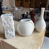 Set of 3 Kaiser M Frey white bisque vases displayed on table showing their shapes and designs