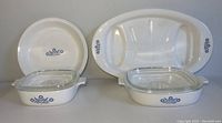 Front view of the Corning Ware Blue Cornflower set showing the divided platter, casseroles with lids, and pie plate with floral pattern.