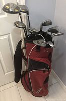 Overview of clubs organized in the red Wilson stand bag with visible pockets and straps