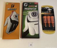 Photo showing packaged Bridgestone eGlove, FootJoy WeatherSof glove, and Brush-T oversized golf tees