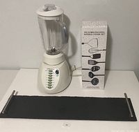 Photo showing Black & Decker blender, boxed stainless steel utensil set, and canvas stone slate serving tray with metal handles